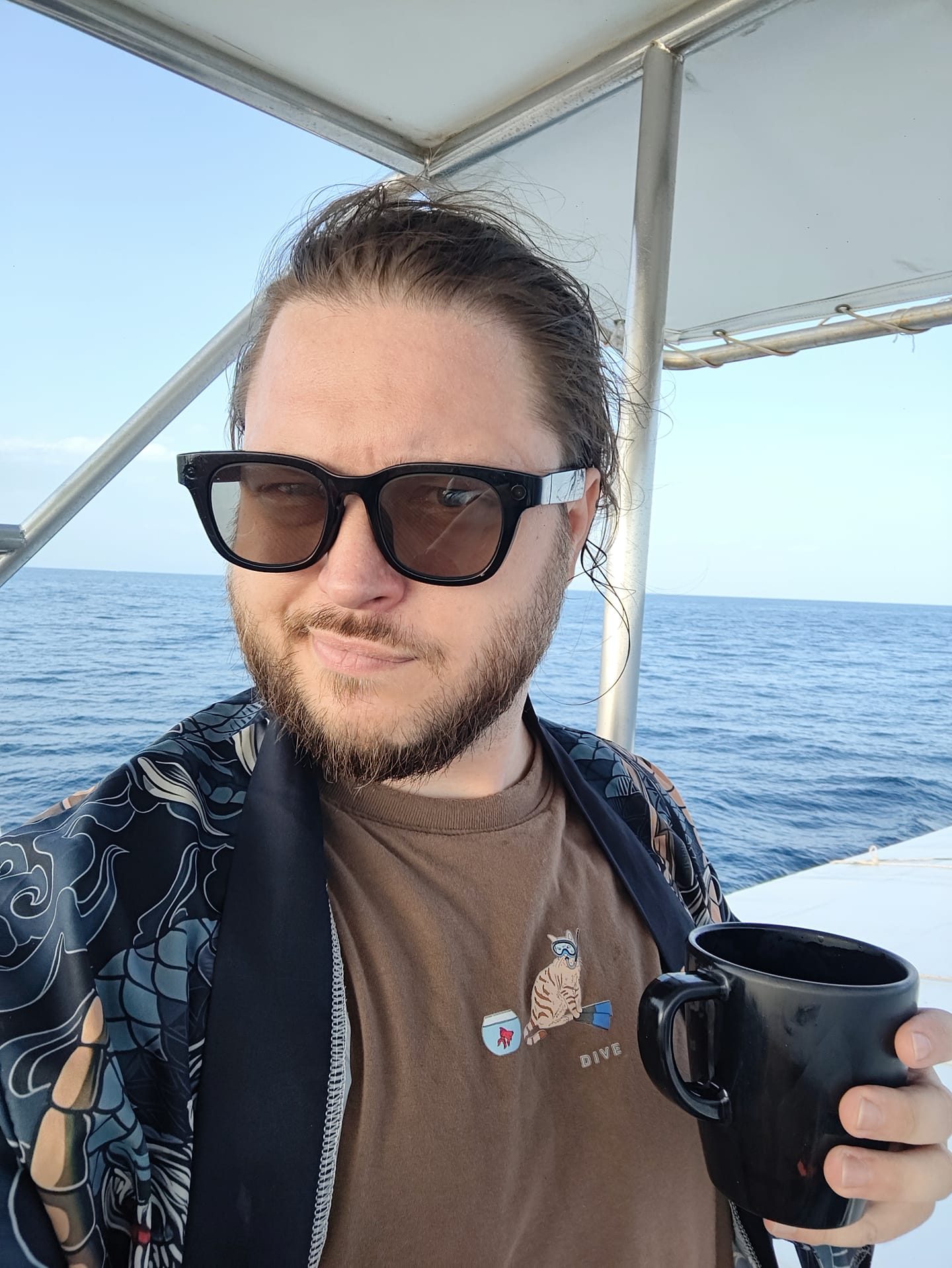 Данила с кружкой на лодке в открытом море
